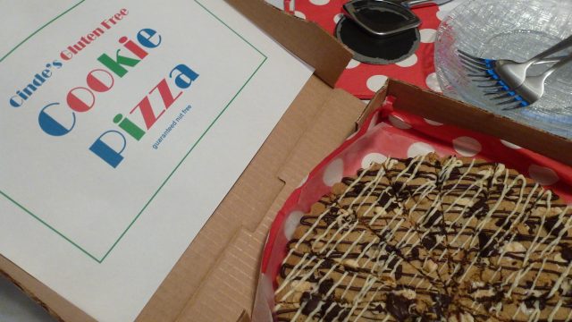 A pizza box with a gluten free Chocolate Chip Cookie Pizza.