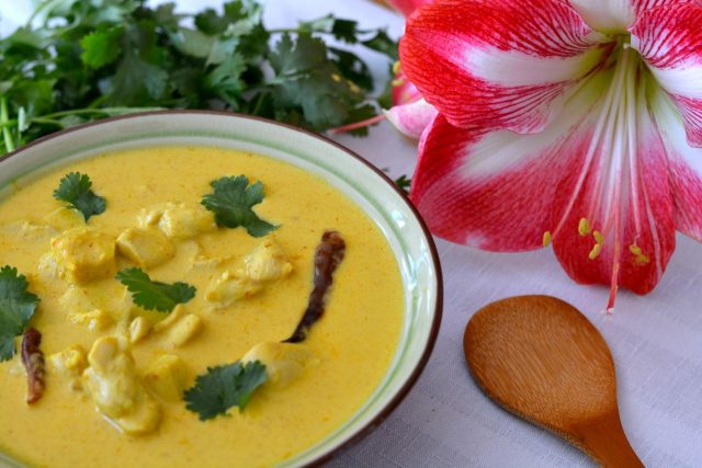 A bowl of Thai Yellow Chicken Curry garnished with fresh cilantro.