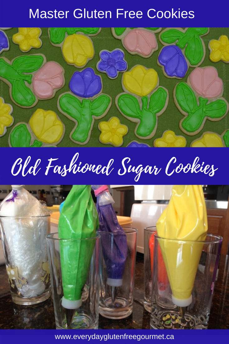 Old Fashioned Sugar Cookies in flower shapes decorated with royal icing in yellow, pink and purple.