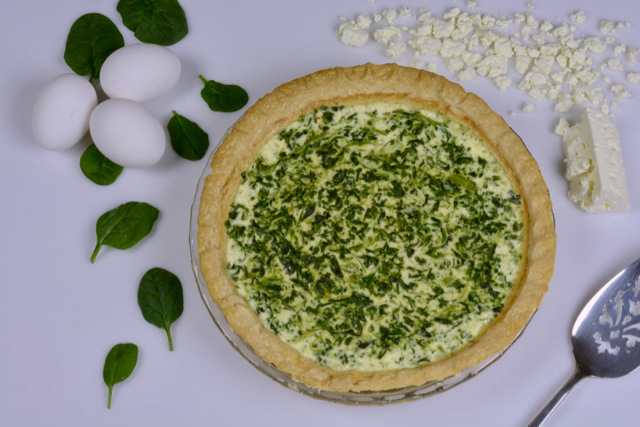 A Spinach Feta Quiche ready to be cut and served.