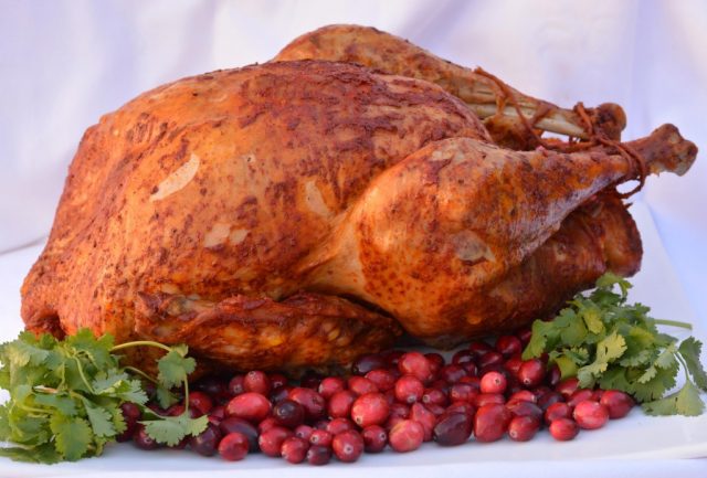 A Turkey Feast featuring an Achiote Butter Basted Turkey ready for carving.