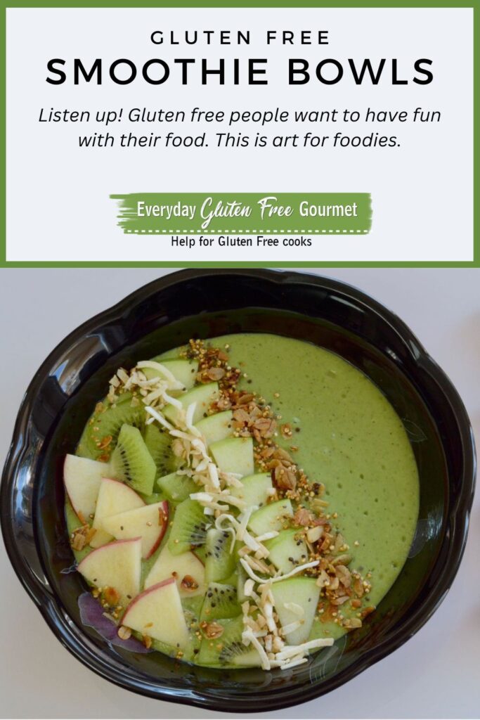 A green smoothie in a bowl, half covered with a garnish of cut up apple and kiwi, sprinkled with granola.