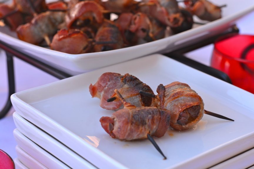 A plate with three gluten free Chorizo Stuffed Bacon Wrapped Dates.