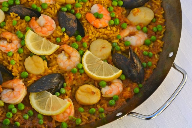 A paella pan filled with Paella with Seafood