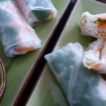Two plates with Vietnamese Salad Rolls cut up and ready to eat with Nuoc Cham dipping sauce.