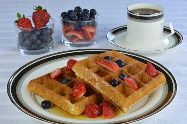 Gluten Free Waffles with strawberries, blueberries and maple syrup.