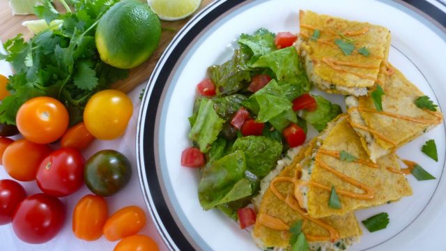 A plate with crab quesadillas with a drizzle of chipotle mayo