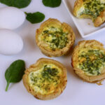 Three individual quiches made with spinach and feta.