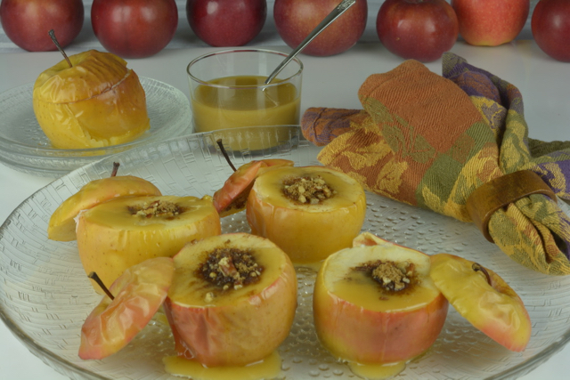 A platter of stuffed Baked Apples with Caramel Sauce drizzled on top.