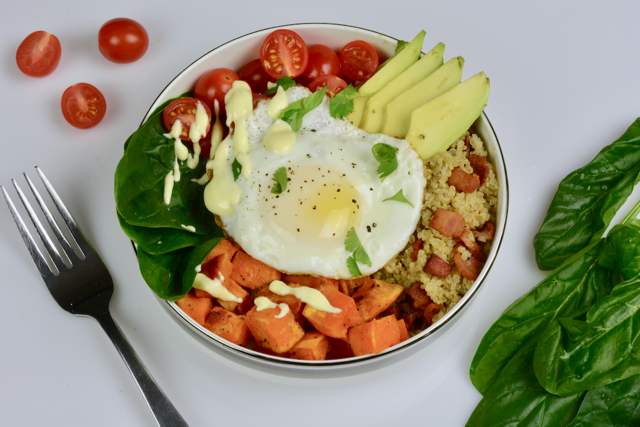 Breakfast Power Bowl filled with cooked quinoa, avocado, spinach, tomatoes and egg and topped with hollandaise sauce for a special treat.