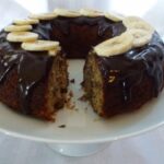 Banana Bundt Cake drizzled with Chocolate Glaze and topped with banana slices.
