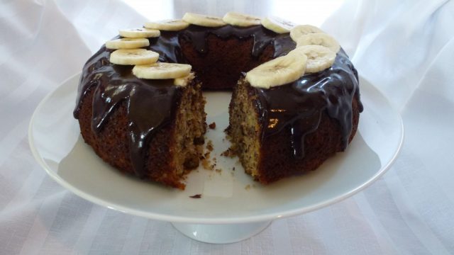 Banana Bundt Cake drizzled with Chocolate Glaze and topped with banana slices.