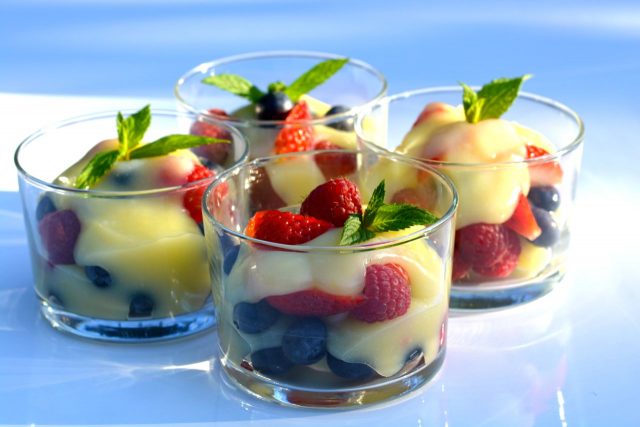 Little dishes of fresh berries topped with homemade lemon curd.