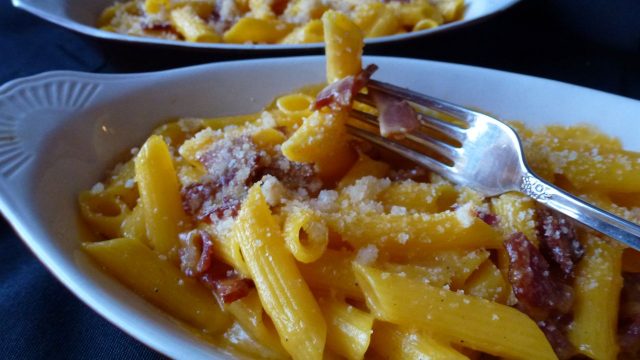 A dish of gluten free macaroni and cheese made with sharp cheddar and bacon.