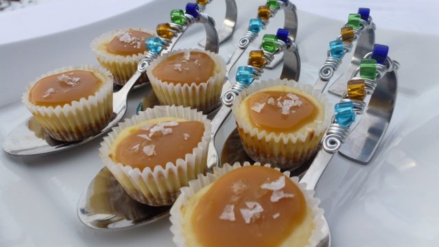 Salted Caramel Cheesecake Cupcakes served on fancy spoons.