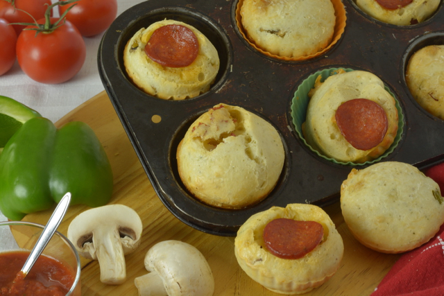 Pepperoni Pizza Cheese Buns in the pan surrounded by green pepper, mushrooms and pizza dipping sauce.