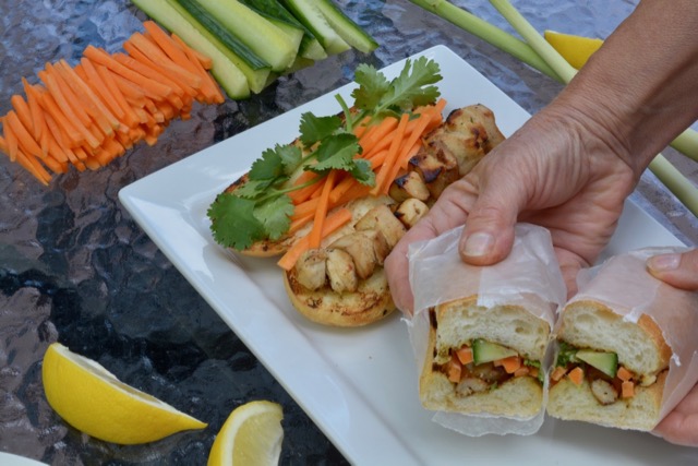 A Vietnamese Lemongrass Chicken Sub wrapped in wax paper and cut, ready to devour.