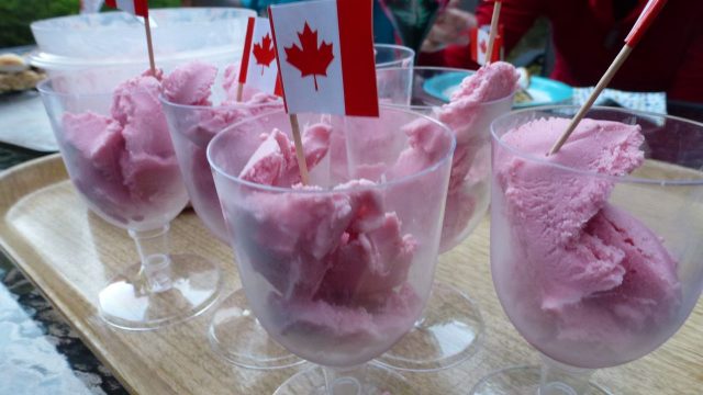 Glasses of gluten free strawberry cheesecake ice cream and a tiny Canadian flag.