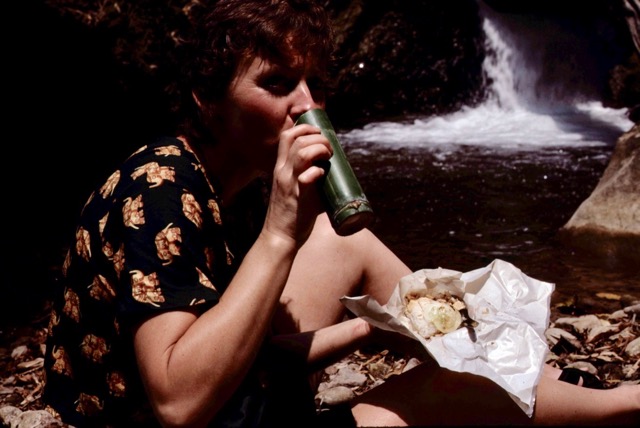 Cinde on a trek in Thailand enjoying freshly boiled tea from a bamboo cup.