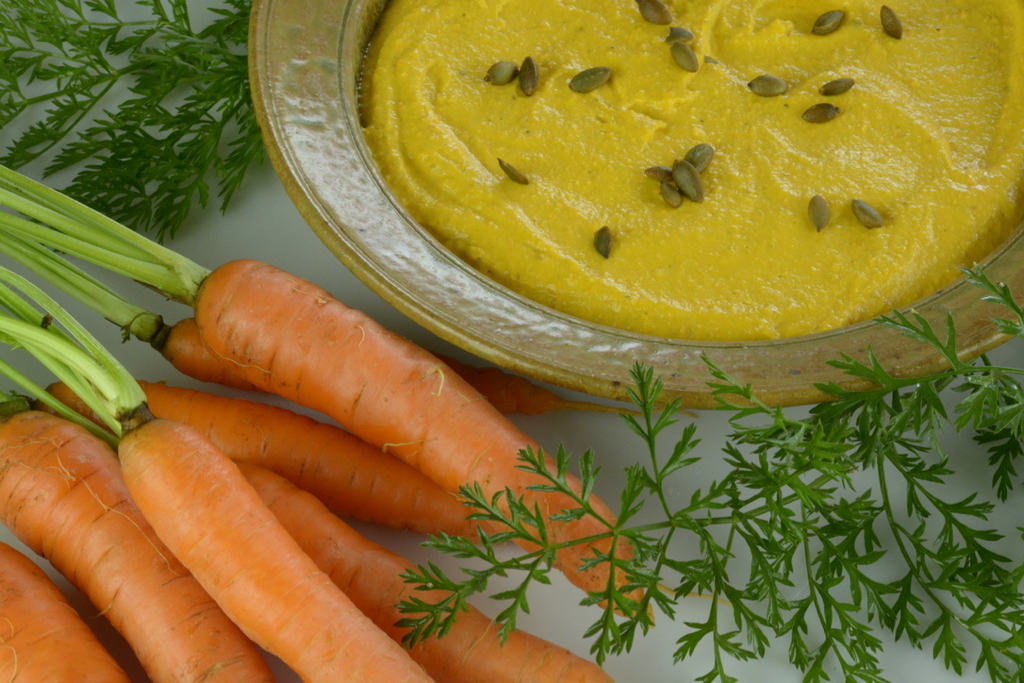 Roasted Carrot Hummus sprinkled with toasted pumpkin seeds is perfect for fall.