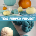A display of different sizes of teal and white pumpkins with one large, orange pumpkin.