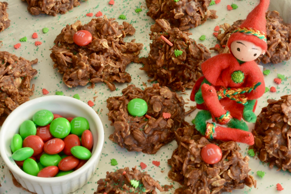 Uncooked Dainties decorated with red and green sprinkles being guarded by a Christmas elf.
