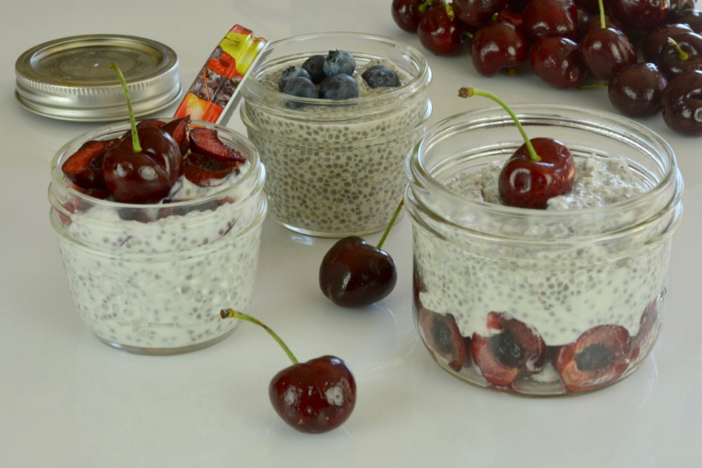 Mason jars of Chia Pudding with yogurt and fresh berries.