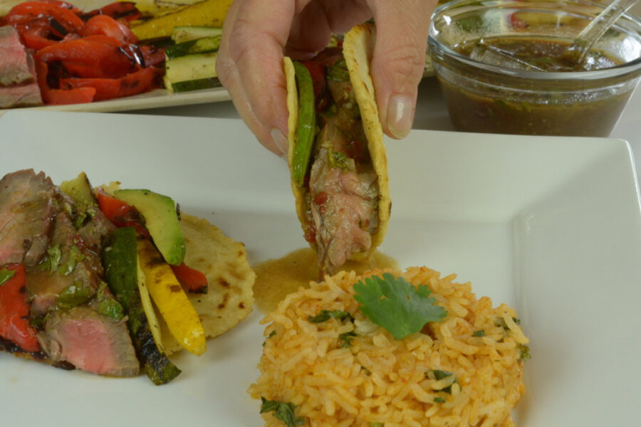 Flank Steak in corn tortillas with grilled vegetables and Mexican rice.