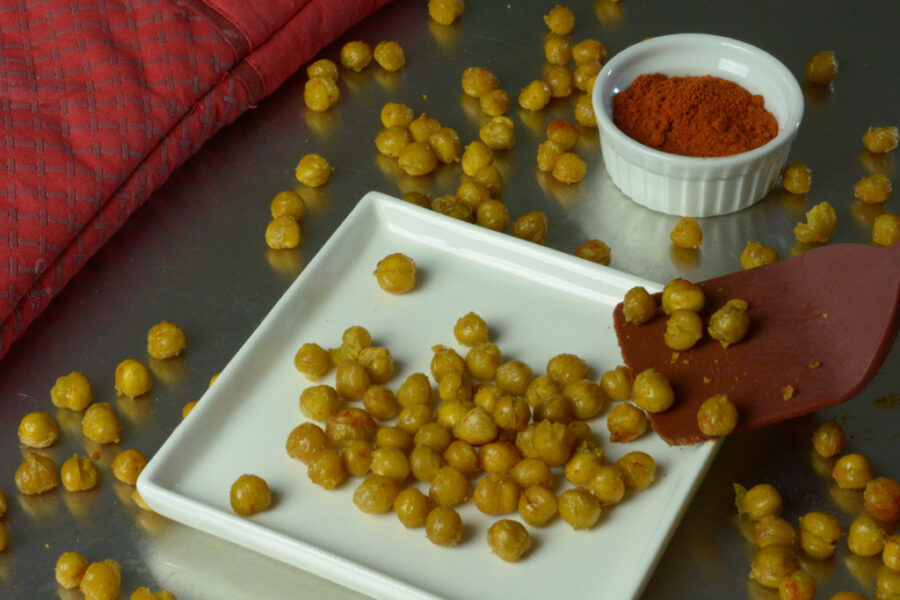 Roasted Chickpeas on a plate with a dish of paprika, a great high fibre gluten free recipe..