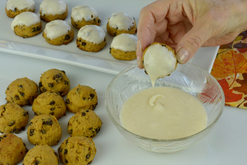 Dipping Pumpkin Spice Cookies in icing.