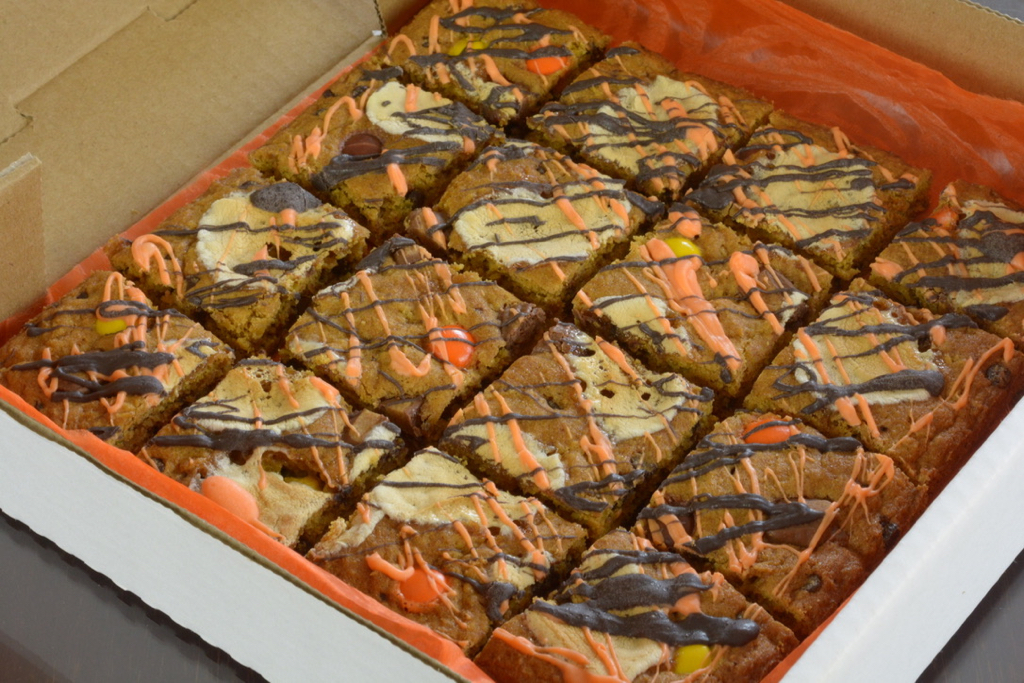 A square Halloween Pumpkin Chocolate Chip Cookie Pizza in a box.