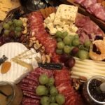 A gluten free Charcuterie Board with meats, cheeses, dried and fresh fruit, nuts and crackers.