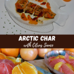 A plate with baked Arctic Char covered in citrus sauce with whole segments of citrus fruit and a sprinkling of chives.