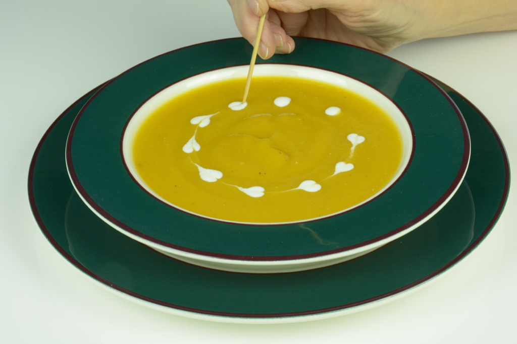 Drawing a skewer through dots of thinned yogurt to make tiny hearts.