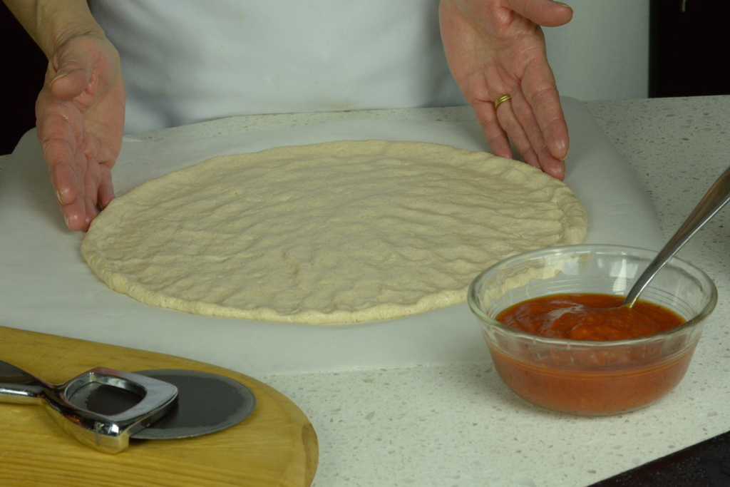 flour measured by weight to make this California pizza dough ready for the oven.