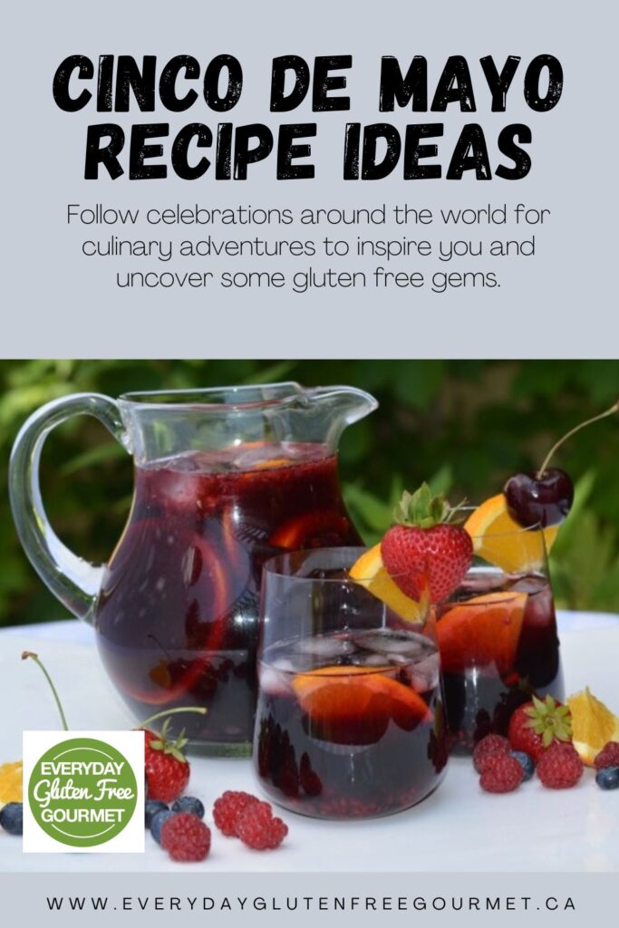 A pitcher and glasses full of homemade Prosecco Berry Sangria surrounded by fresh berries.