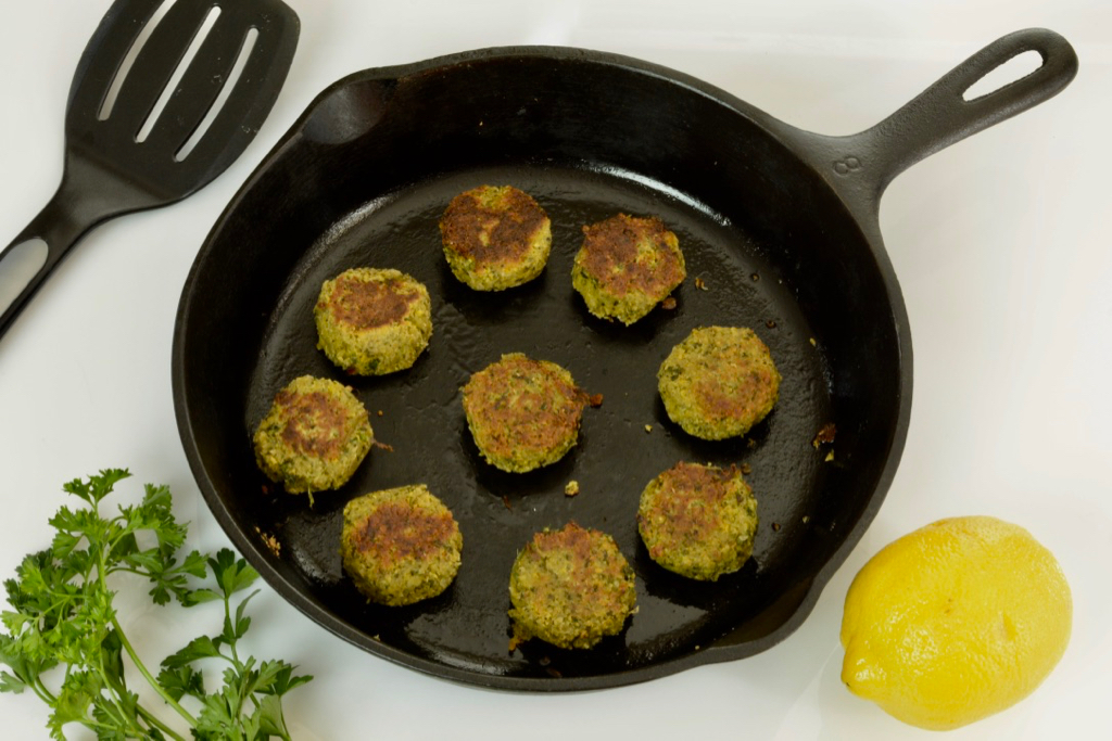 A cast iron frying pan with just cooked (and slightly flattened) falafel balls.