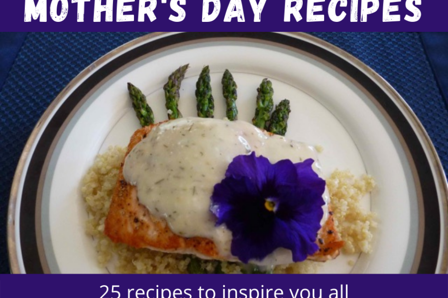 Grilled salmon on top of a fan of asparagus spears covered in a creamy sauce and topped with a purple pansy.