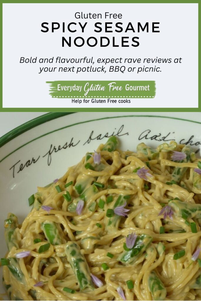 A bowl of gluten free Spicy Sesame Noodles with green beans and a sprinkling of fresh chives.