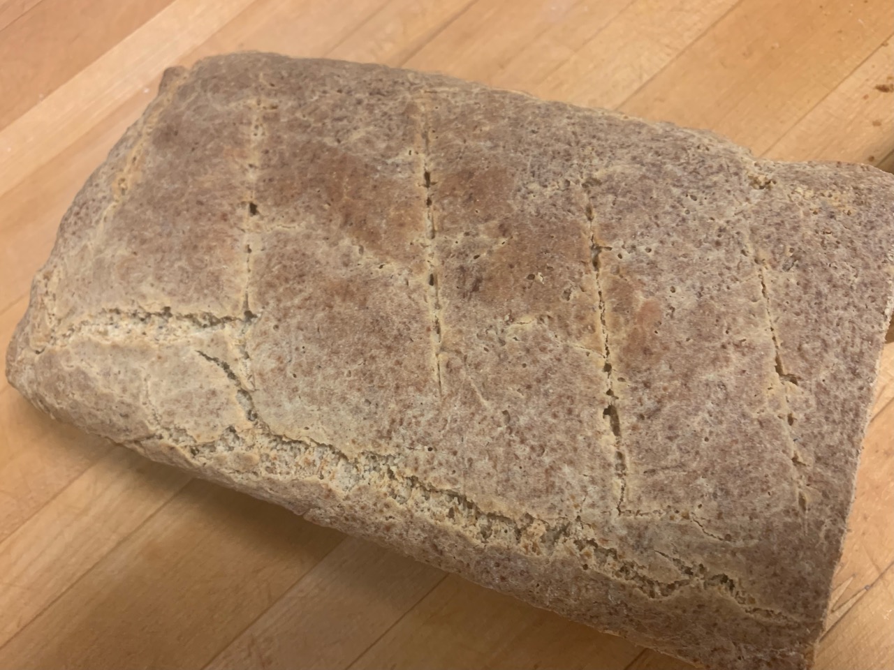 Top down look at Brad's Crusty Bread cooked in a loaf pan with hash marks across the top.