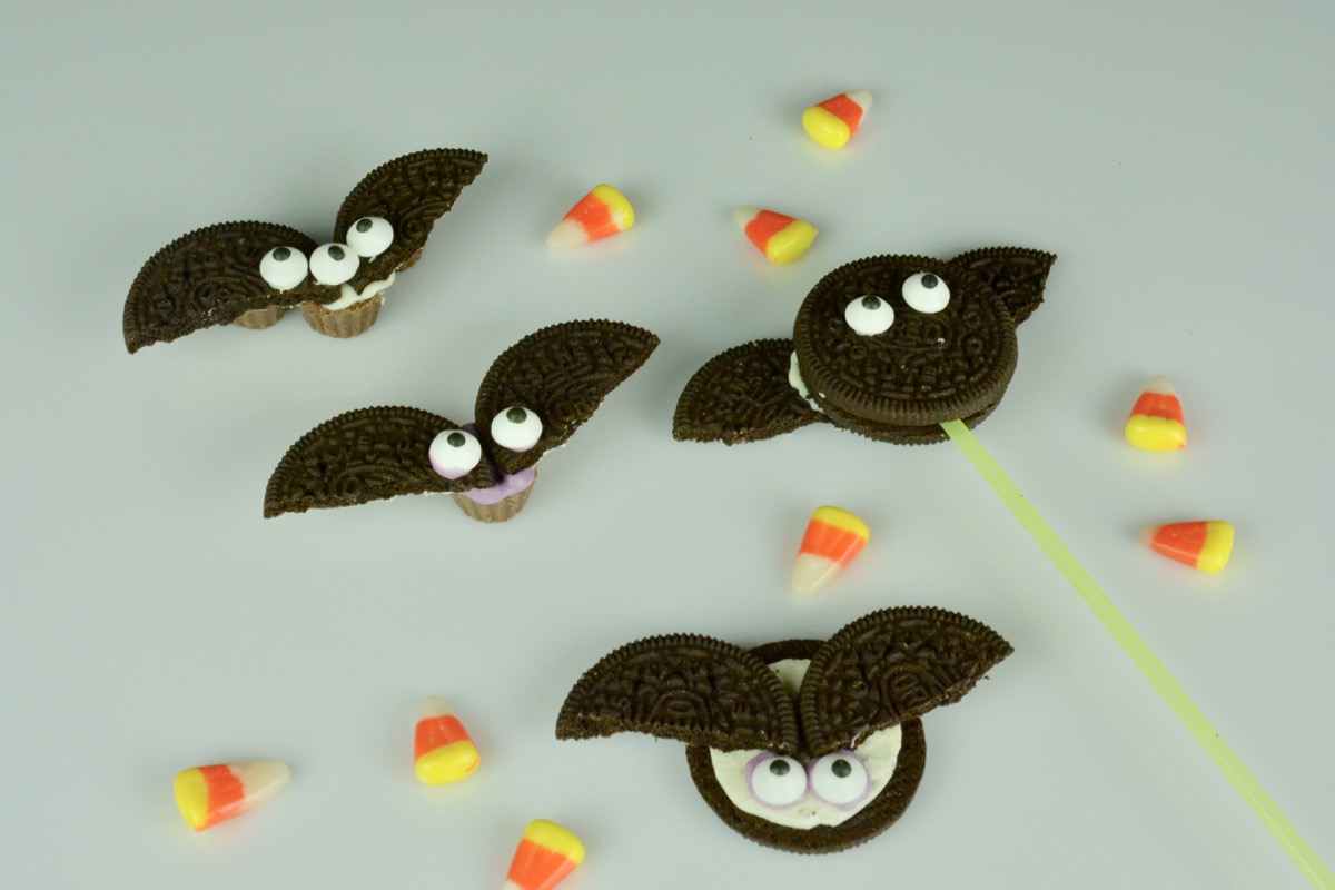 White plate with 3 versions of an Oreo bat with google eyes and candy corn beside them.