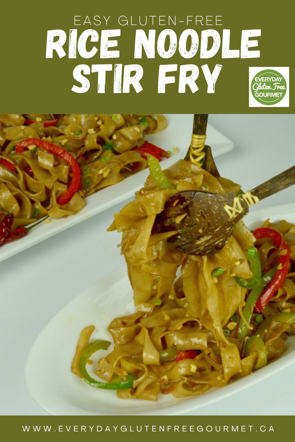 A spoon and fork lifting some rice noodle stir fry out of a serving dish.