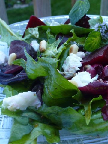 A plate of Salad with Beets, Goat Cheese and Pine Nuts.
