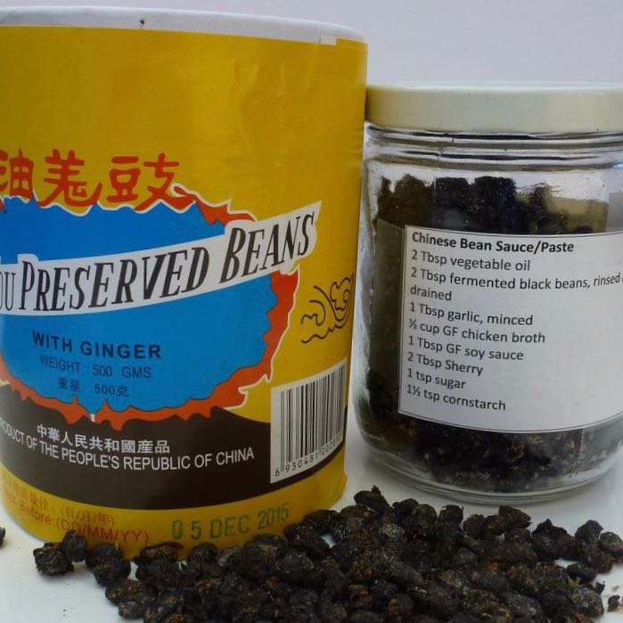 Preserved Chinese Black Beans in the yellow box plus a jar full of them with the recipe for Black Bean Sauce taped to the outside.