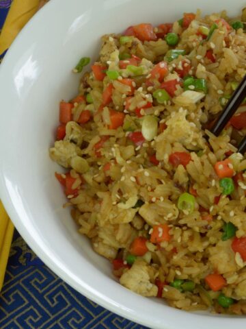 A bowl of Chicken Fried Rice with chopsticks.