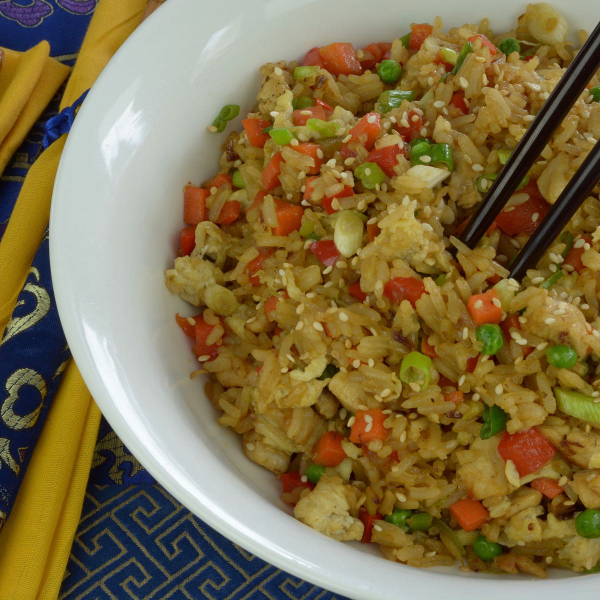A bowl of Chicken Fried Rice with chopsticks.