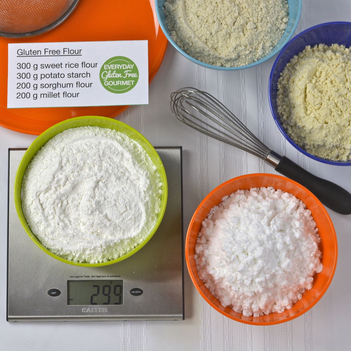 A top down look at 4 bowls of gluten free flour; millet, sorghum, sweet rice flour and potato starch.