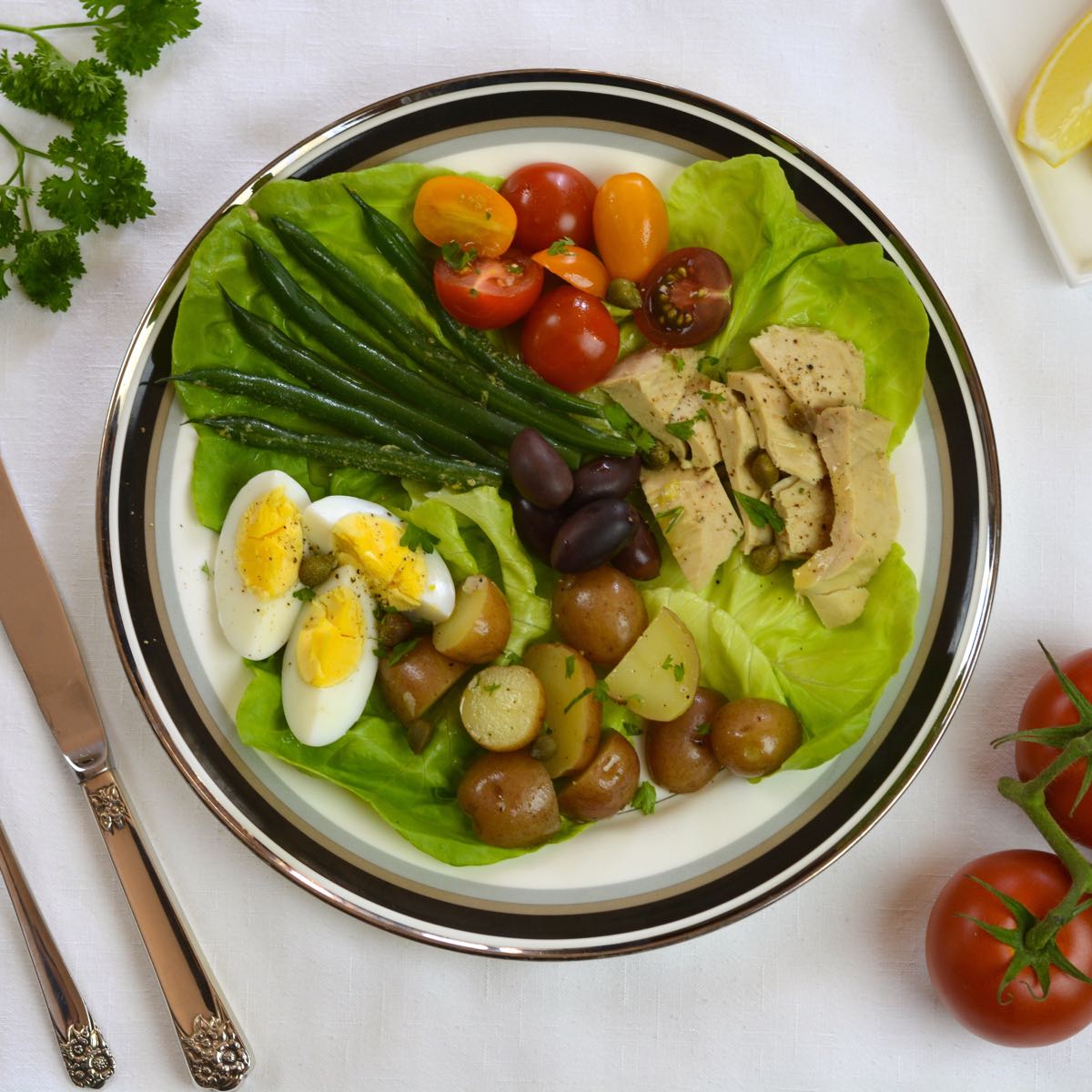 A composed Salad Nicoise: hard boiled egg, potatoes, green beans, tomatoes and canned tuna with an amazingly delicious vinaigrette dressing.
