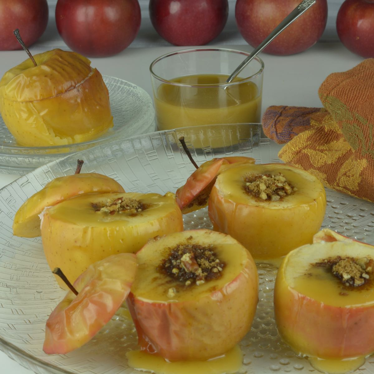 A platter of stuffed Baked Apples with Caramel Sauce drizzled on top.