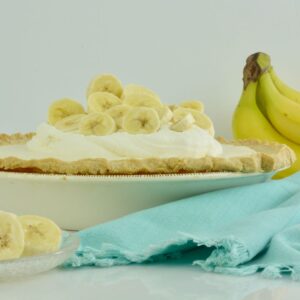 A whole Banana Cream Pie covered in whipped cream and sliced bananas.